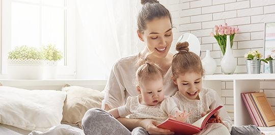 Mom reading a book to daughters - Danbury family law attorney